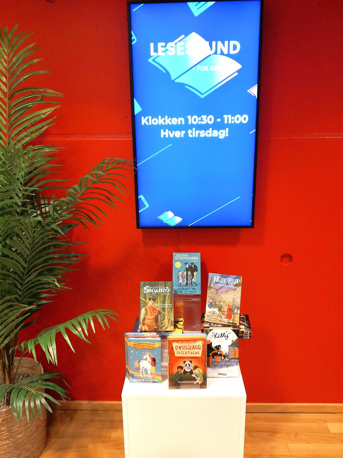 Informasjonsskjerm som viser at det er lesestund hver tirsdag klokken 10.30 til 11.00. Foto.